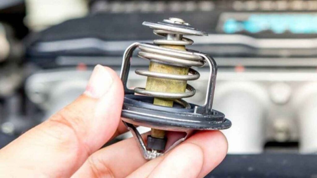 Mechanic examining new car thermostats during engine temperature repair.