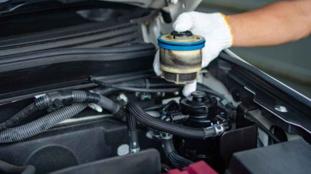 Mechanic replacing car fuel filter to restore fuel flow.