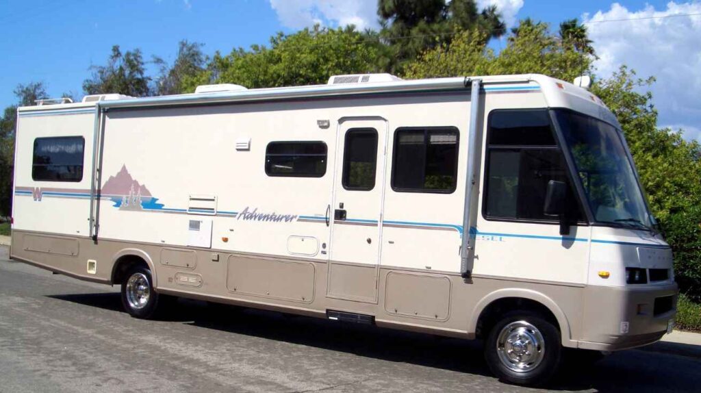 Compact Winnebago Micro Minnie trailer parked at a scenic park campsite.