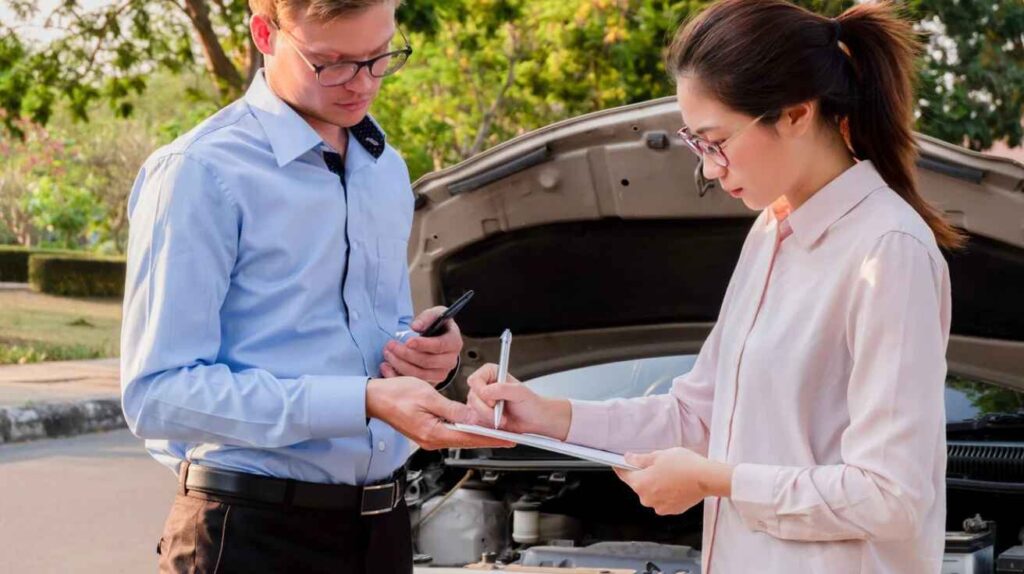 Insurance agent giving documents to a driver.